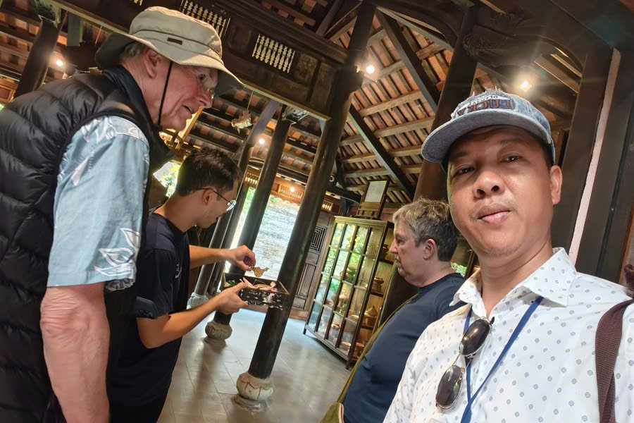 Mr. Viet Nguyen with guests visiting a traditional ancient house during a Central Vietnam Tour Package in Hue.