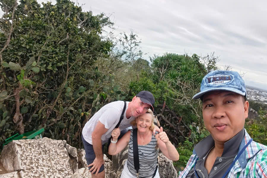 Mr. Viet Nguyen posing with guests at the summit of the Marble Mountains during a Central Vietnam Private Tour.