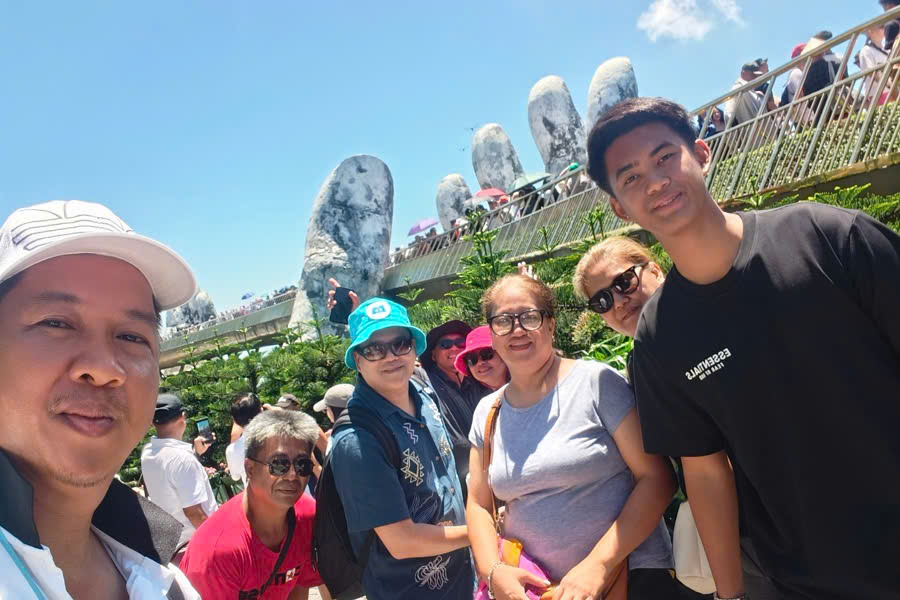 Viet Nguyen taking a selfie with guests at the Golden Bridge in Ba Na Hills during a private guided tour.