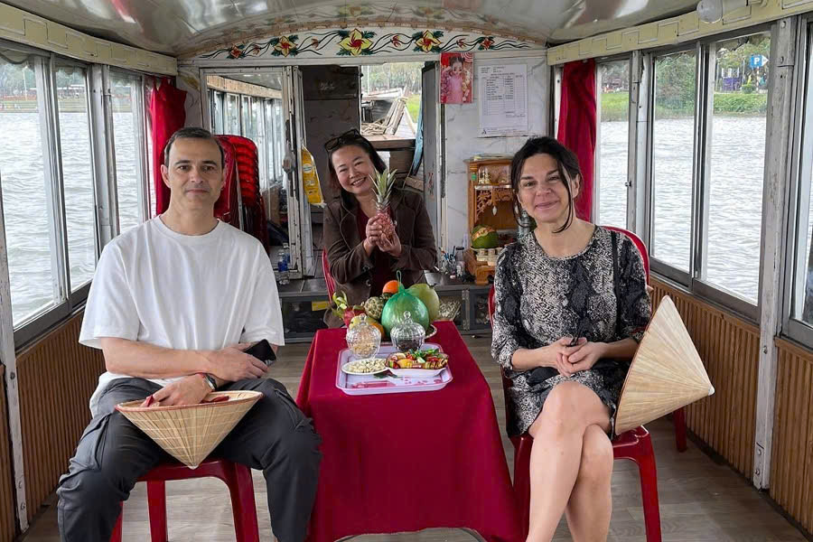 Tour guide and guests enjoying a Dragon Boat cruise on the Perfume River in Hue