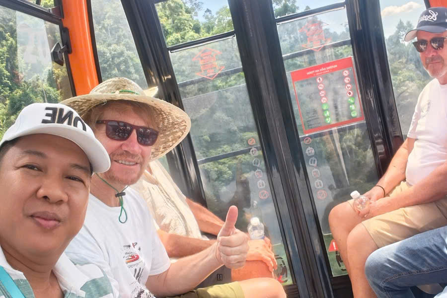 Viet Nguyen takes a selfie with guests during a cable car ride at Ba Na Hills