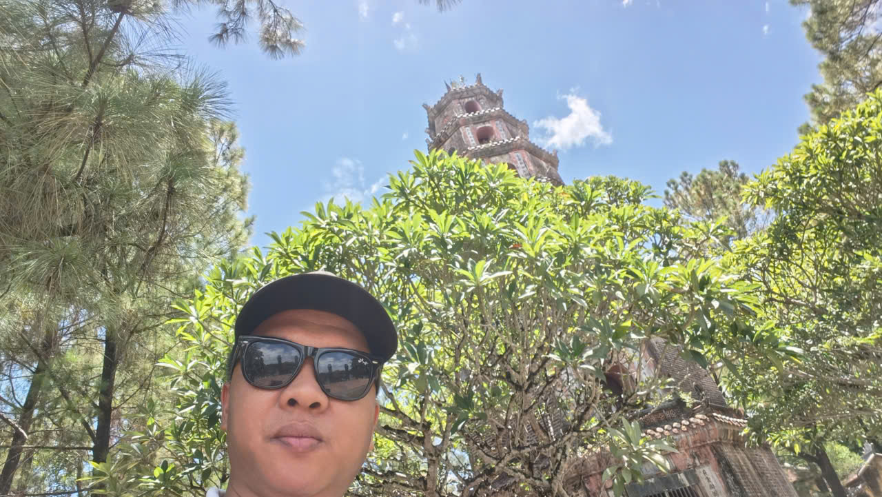 Viet Nguyen standing in front of Phuoc Duyen Tower at Thien Mu Pagoda in Hue, Vietnam.