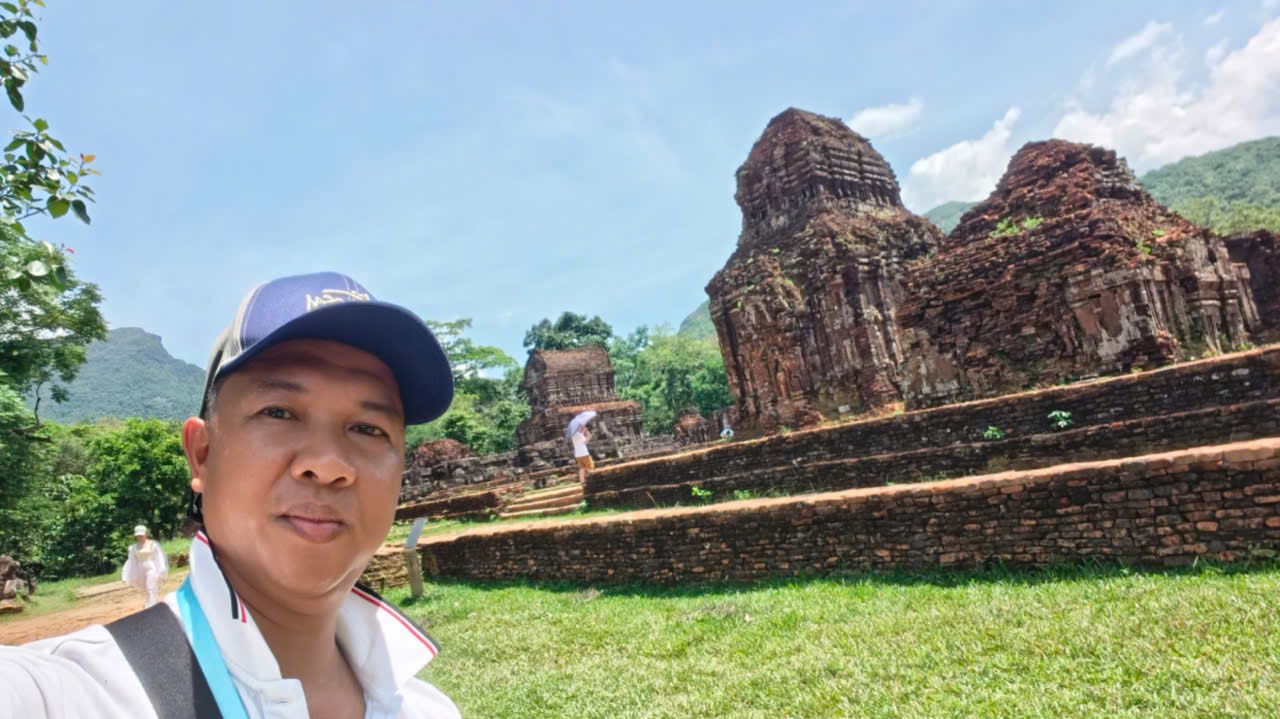 Viet Nguyen taking a selfie in front of the ancient temples at My Son Sanctuary, a UNESCO World Heritage Site in Central Vietnam.