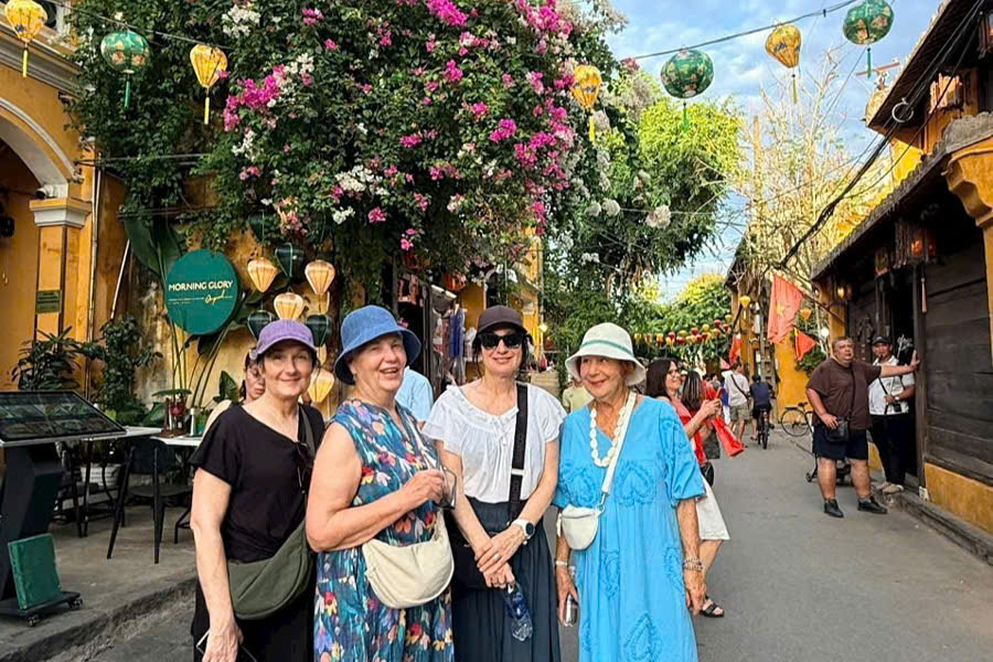 Group taking photos in the middle of Hoi An Ancient Town during an evening tour.
