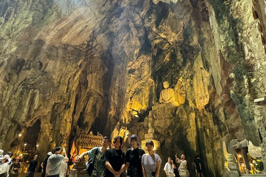 Family group taking photos inside Huyen Khong Cave at Marble Mountains during a private tour from Da Nang to Hoi An.