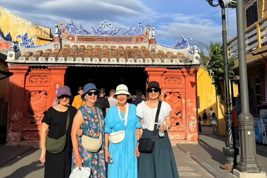 Family group taking photos in front of the Japanese Covered Bridge in Hoi An Ancient Town.