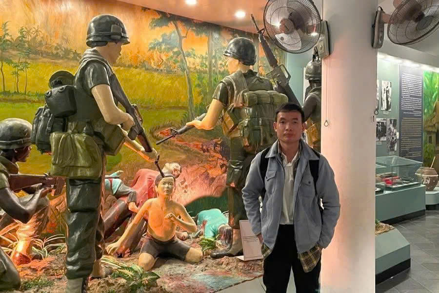 Guest photographing a historical exhibit about the My Lai Massacre at the Son My Memorial Museum in Quang Ngai, Vietnam