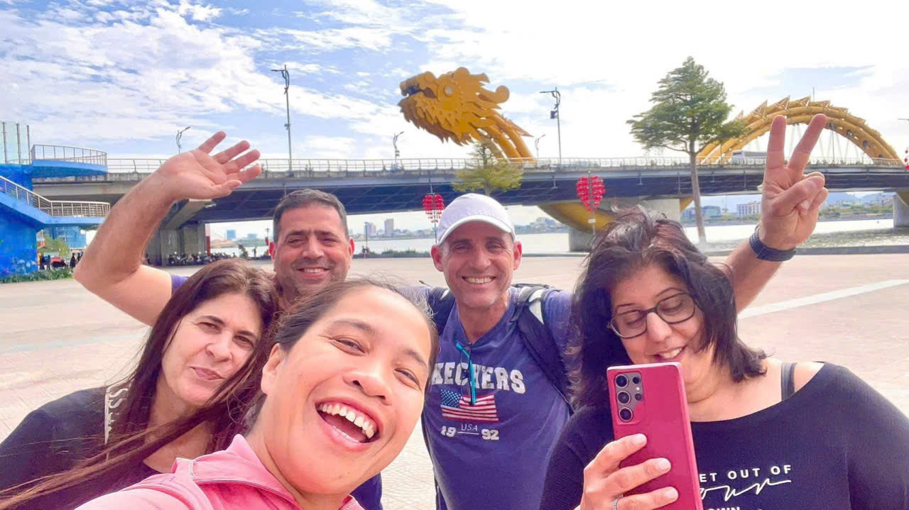 Happy travelers taking a selfie near Dragon Bridge in Da Nang, Vietnam