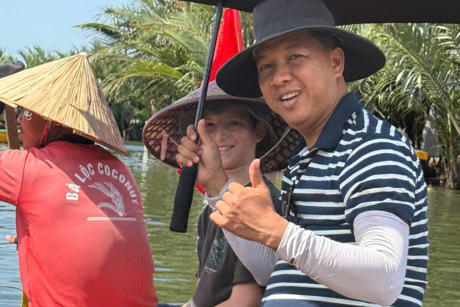 Viet Nguyen taking a photo with guests during a basket boat ride in Cam Thanh Coconut Village