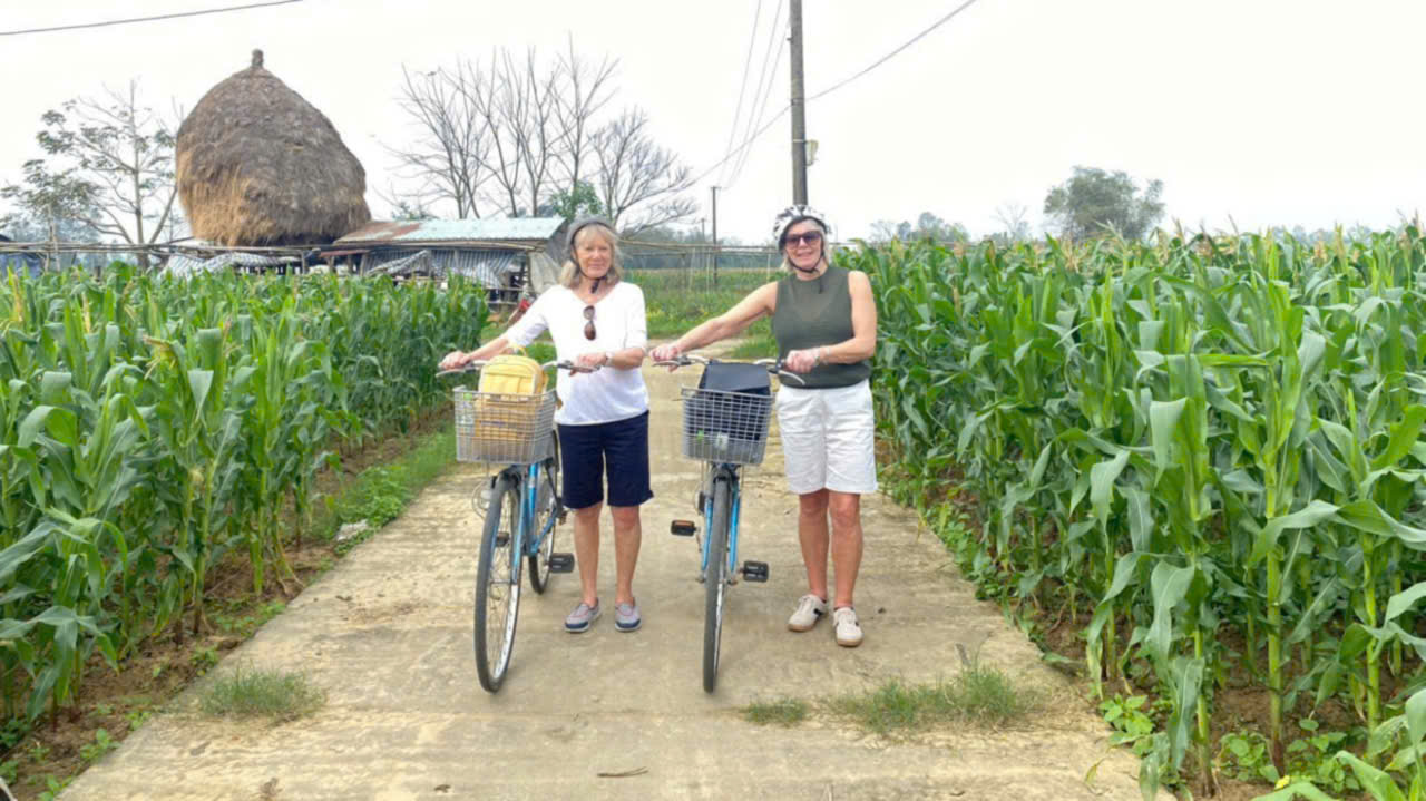 Tourists taking photos in a corn farm during a Hoi An Cycling Tour through the countryside