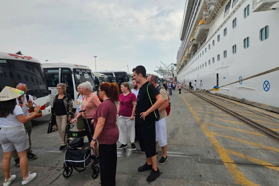 Tour guide welcoming cruise passengers at Phu My Port for a Cu Chi Tunnels tour.