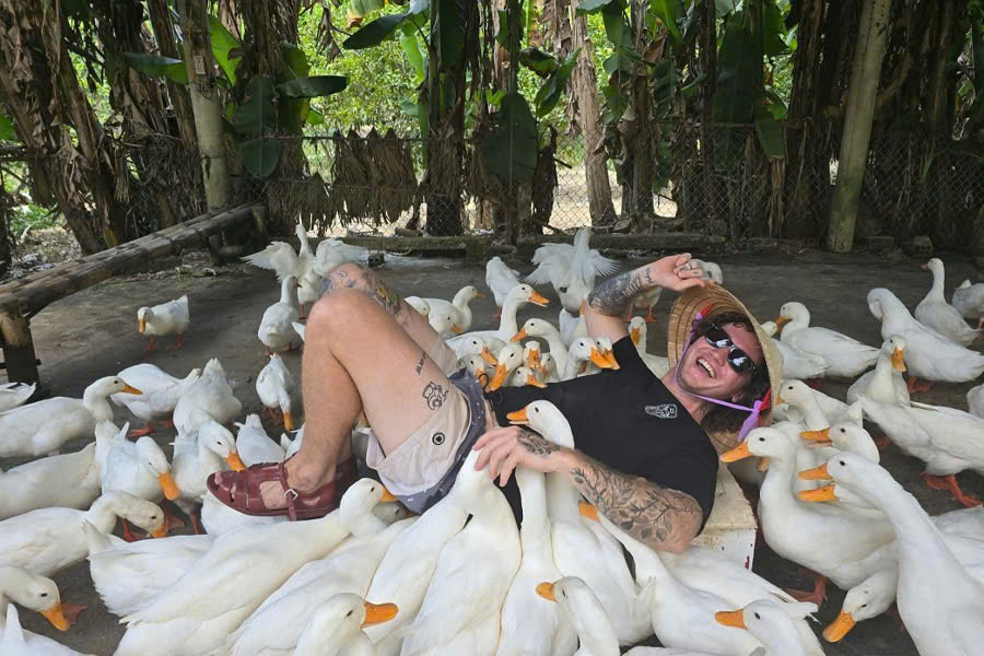 Tourist taking a photo with ducks at Duck Stop Phong Nha, Quang Binh
