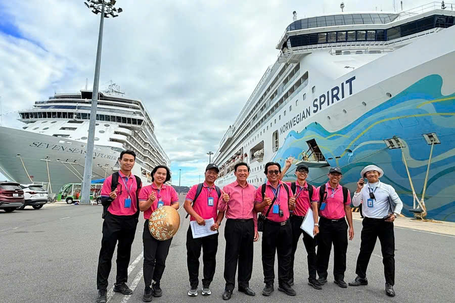 Tour company team taking a photo with a cruise ship at Phu My Port for a Ho Chi Minh City shore excursion.