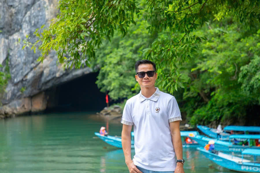 Tourist taking a photo in front of the Phong Nha Cave entrance in Phong Nha-Ke Bang National Park