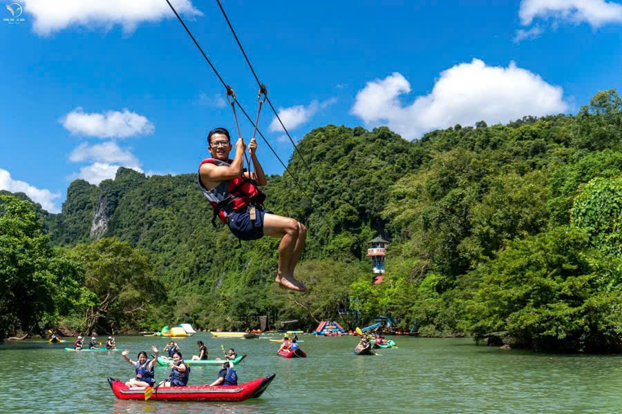 Tourists ziplining across the Chay River during a Phong Nha tour from Dong Hoi