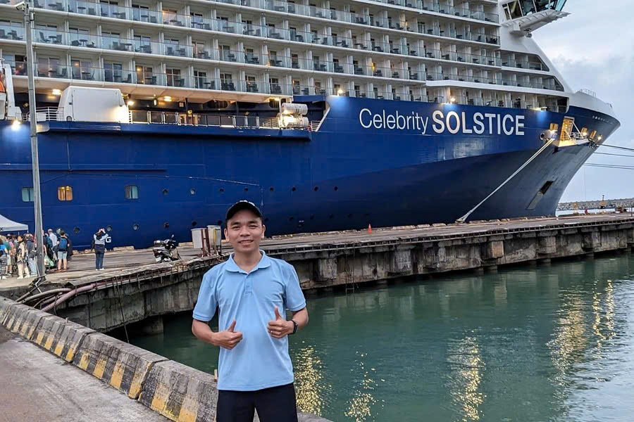 Tour guide taking a selfie with the Celebrity Solstice cruise ship at Phu My Port before a private Cu Chi Tunnels tour.