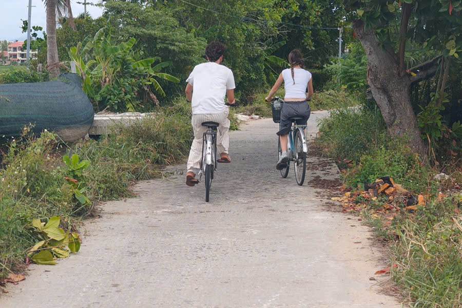 Tourists cycling along a village lane in Hoi An countryside