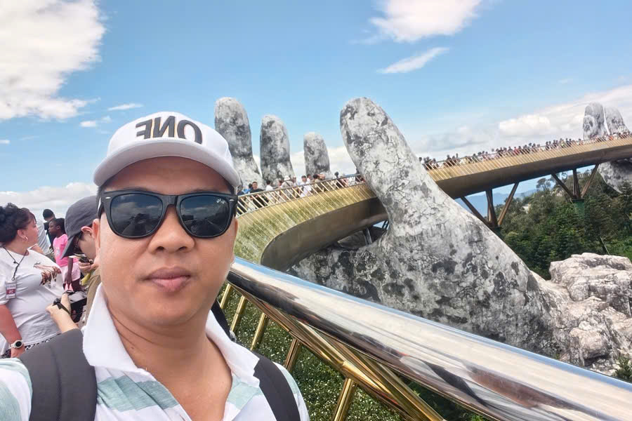 Guide taking a selfie on Golden Hands Bridge at Ba Na Hills