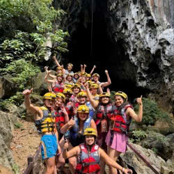 Group taking a photo in front of Dark Cave in Phong Nha.